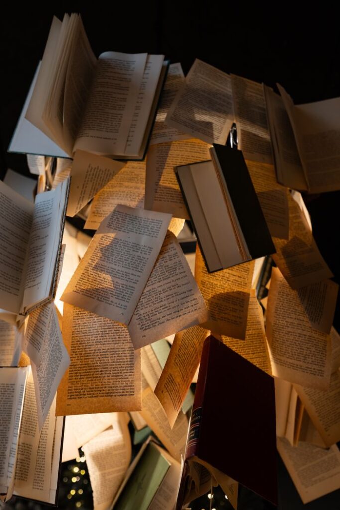 Open books creatively arranged with dramatic lighting, creating a warm and intriguing artistic display.